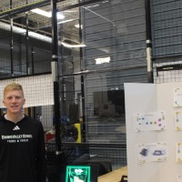 A student standing next to a second karaoke project.